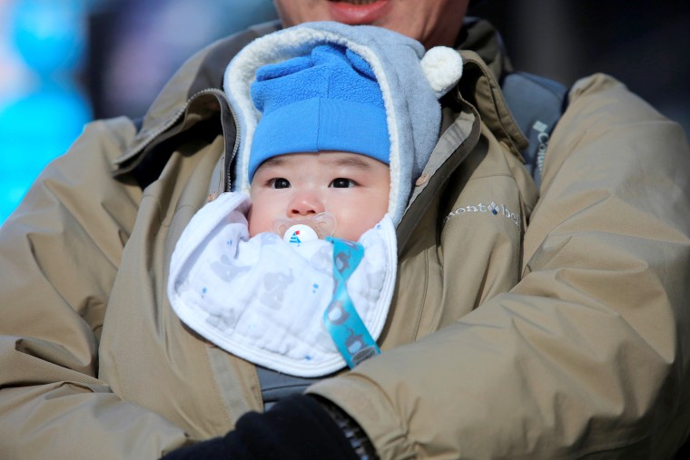 Image: A baby is protected against the cold in Times Square as a cold weather front hits the region in Manhattan