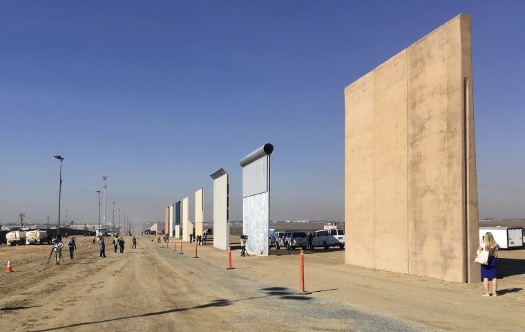 Image: People look at prototypes of a border wall