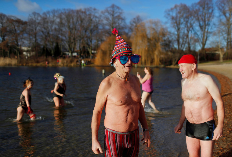 Image: Members of the Berliner Seehunde ice swimmers club take a dip in lake Orankesee during their traditional New Year swimming event in Berlin