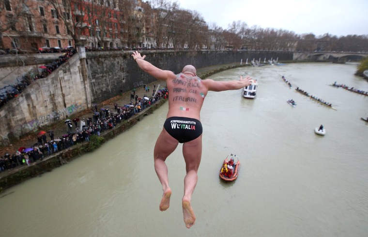 Image: Simone Carabella of Italy dives into the Tiber River from the Cavour bridge, as part of traditional New Year celebrations in Rome