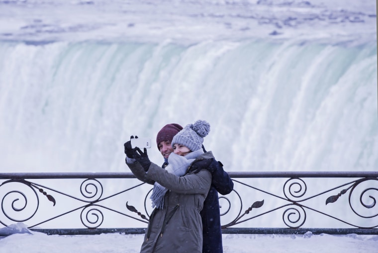 Image: Visitors take photographs at the brink of the Horseshoe Falls in Niagara Falls