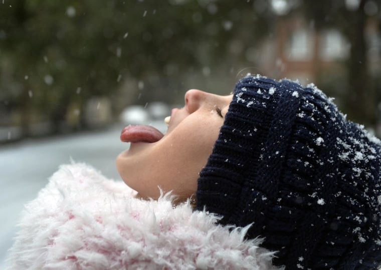 Image: Mirni Dulany, 10, gets a taste of the snowflakes