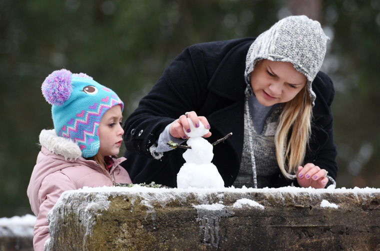 Image: Stephanie Johnson from Hilliard, Fla., puts the final touches on her tiny snowman