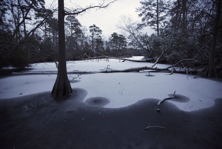 Image: snow covers the frozen waters of the Lake Lawson Lake Smith Natural Area in Virginia Beach