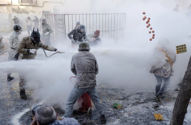 Image: Revelers dressed in mock military outfits battle with flour, eggs and firecrackers