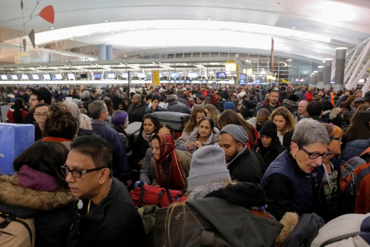 Image: Large crowds try to make their way through the departures area of Terminal 4 at John F. Kennedy International Airport following a series of delayed and canceled flights and a water main break in New York City