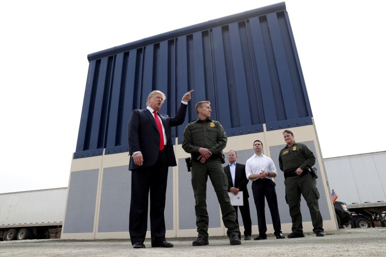 Image: President Donald Trump talks with a U.S. Customs and Border Protection Border Patrol Agent while touring U.S.-Mexico border wall prototypes near the Otay Mesa Port of Entry in San Diego, California, on March 13, 2018.