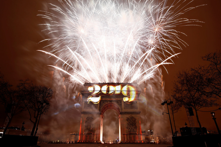 Image: Fireworks explode during the New Year's celebrations at the Arc de Triomphe in Paris