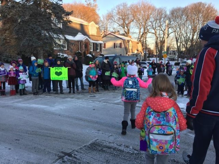 Students and parents line up to welcome girl back to school after cancer battle.