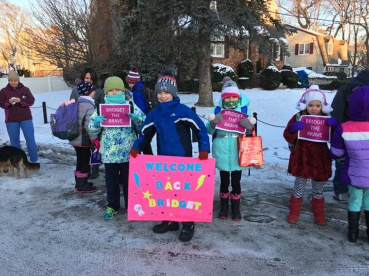 Students and parents line up to welcome girl back to school after cancer battle.