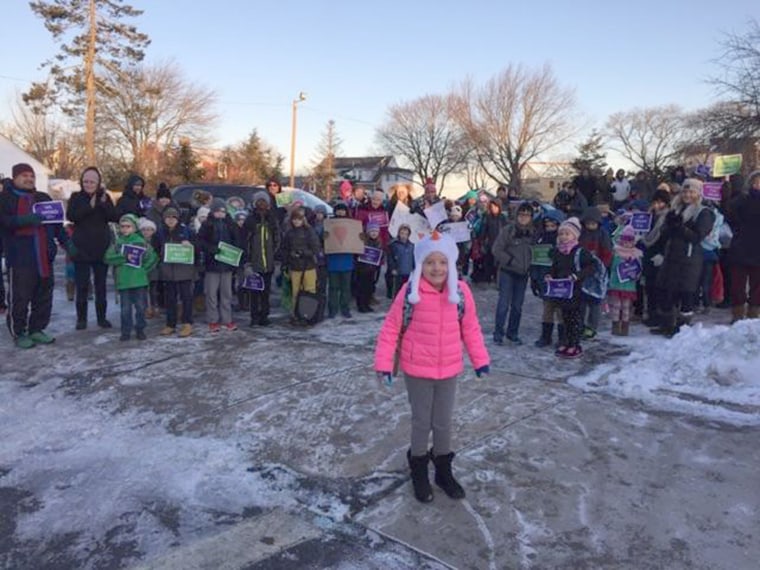 Students and parents line up to welcome girl back to school after cancer battle.