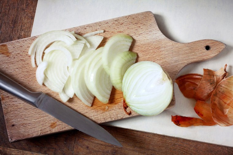 Sliced onion on wooden cutting board