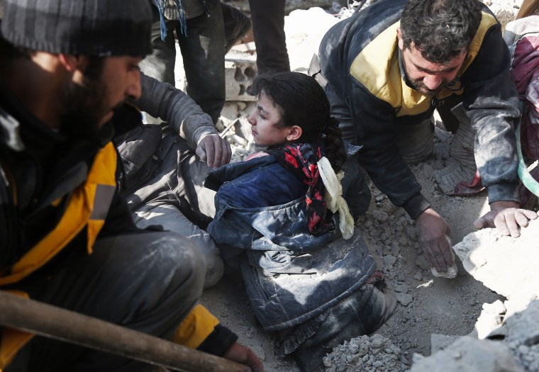 Image: Volunteers from the Syrian Civil Defense dig a girl out of the rubble