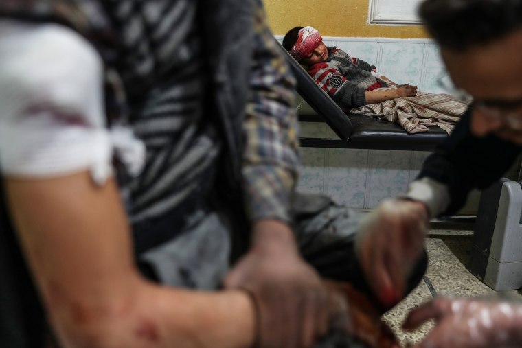 Image: Medical staff treat the injured inside a hospital after several airstrikes on Douma