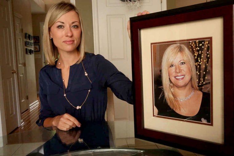 Kim Pack poses with a photo of her late mother, talk-show host April Kauffman.