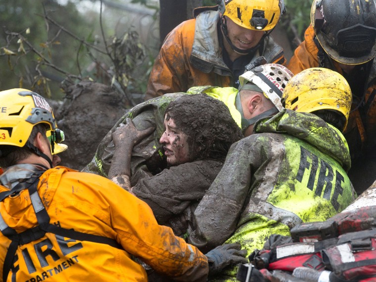 Image: Emergency personnel carry a woman rescued from a collapsed house after a mudslide in Montecito