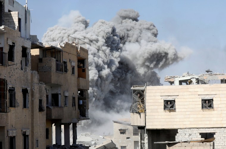 Image: Smoke rises at the positions of the Islamic State militants after an air strike by the coalition forces near the stadium in Raqqa