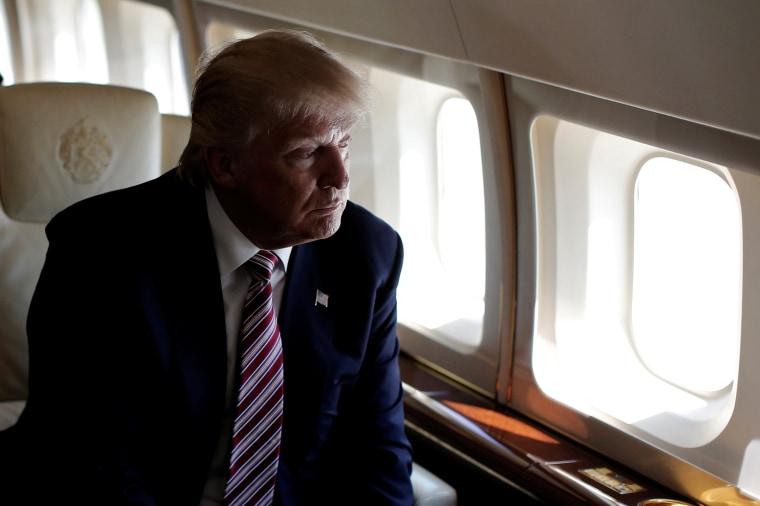 Image: Trump looks out the window as he travels aboard his plane between campaign stops in Ohio