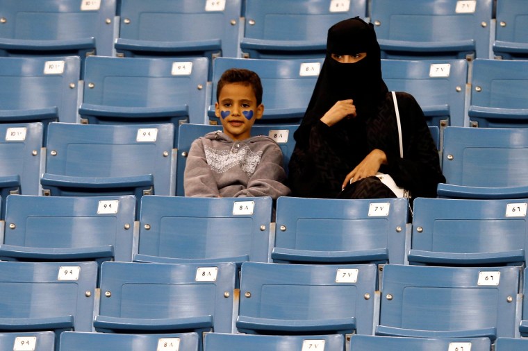 Image: A Saudi woman watches soccer