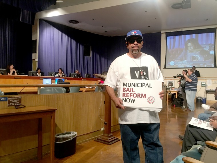 Image: A man poses with a sign at a a recent bail reform vote in New Orleans.
