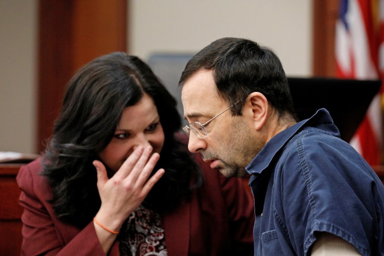 Image: Larry Nassar, a former team USA Gymnastics doctor, who pleaded guilty in November 2017 to sexual assault charges, speaks to his attorney Shannon Smith during his sentencing hearing in Lansing