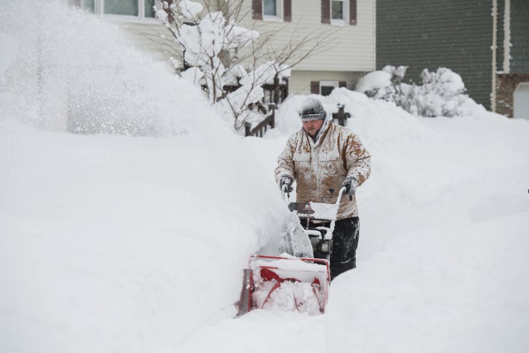 Image: Thomas Berry removes snow from the sidewalk in front of his home after two days of record-breaking snowfall in Erie