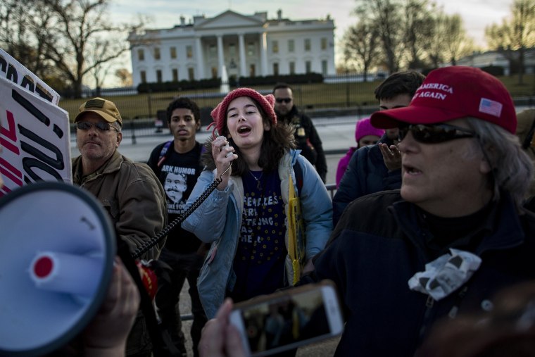 Image: Demonstrators deliver a speech from between Trump supporters.