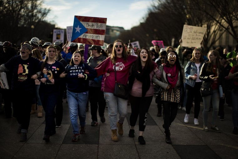 Image: Demonstrators link arms while marching in Washington.