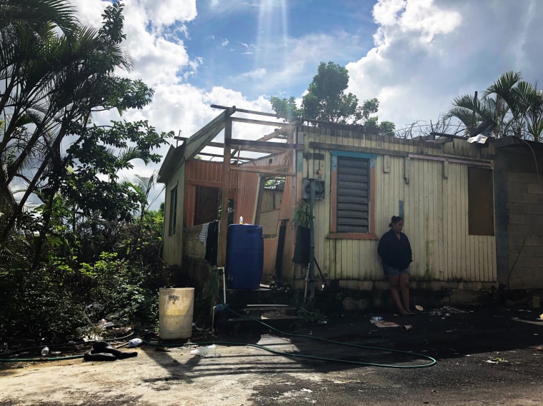 Image: Clarybel Santana leans on what's left of her shredded home