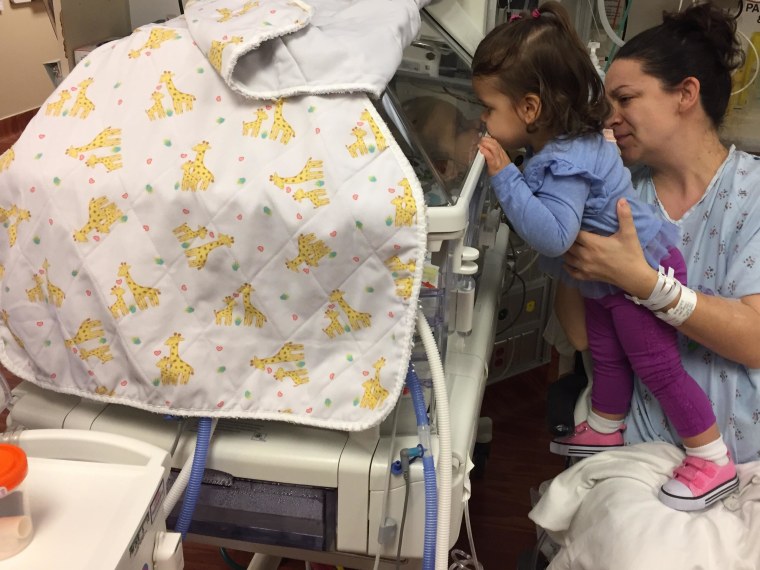 18-month-old Avery takes a look at her baby siblings.