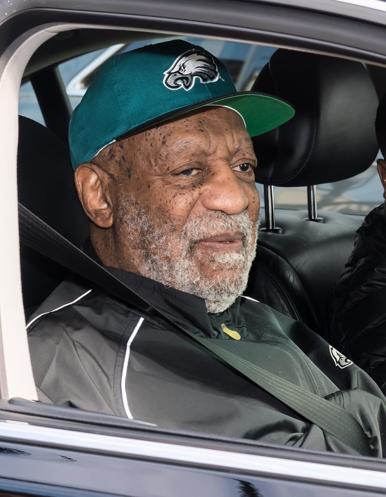 Image: Bill Cosby, wearing Philadelphia Eagles apparel, sits in a car