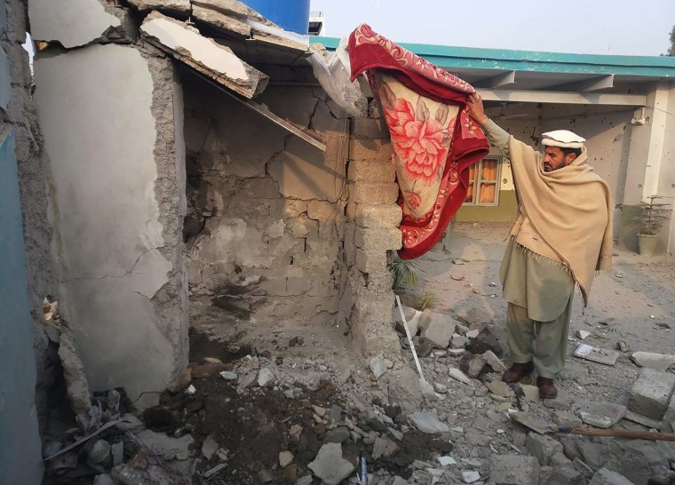 Image: A man inspects the scene of a suspected drone strike 