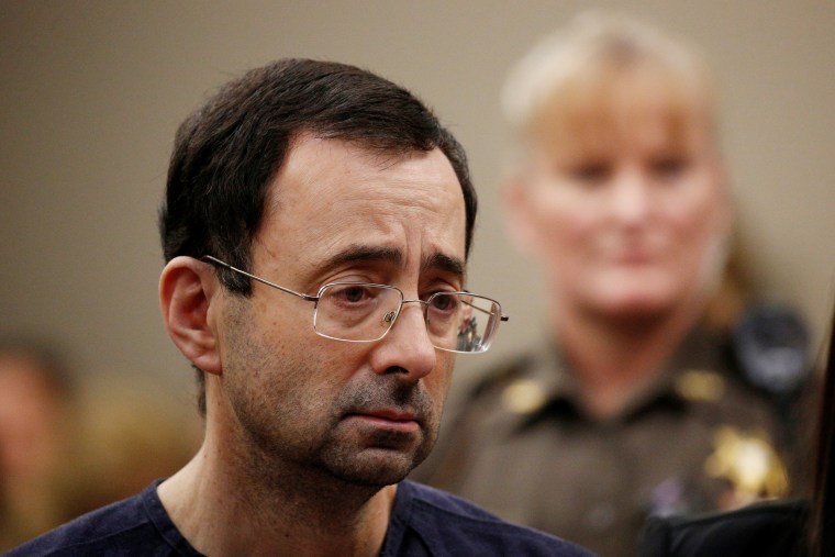 Image: Larry Nassar stands with his legal team during his sentencing hearing
