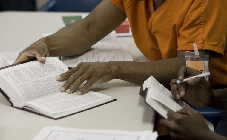 Image: Two male detainees read law books at the
