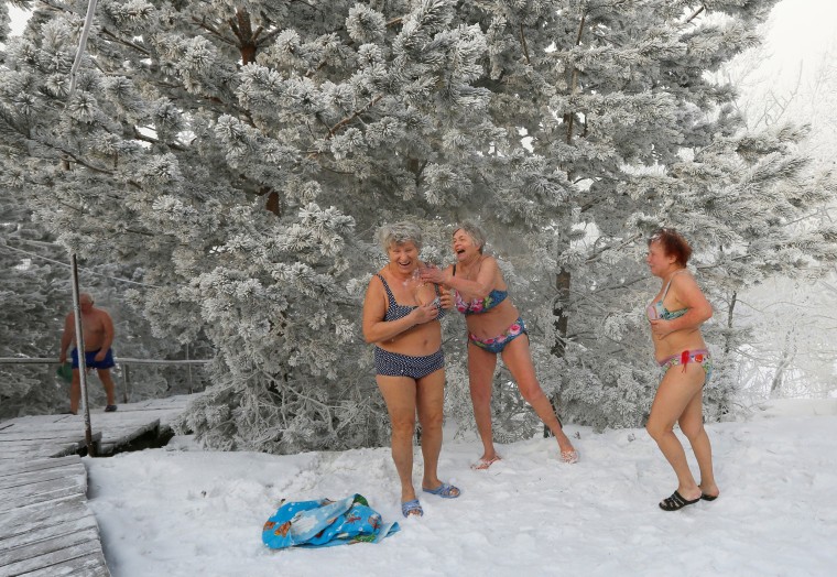Image: Members of the Cryophile winter swimmers club cover themselves with snow after swimming in the Yenisei River
