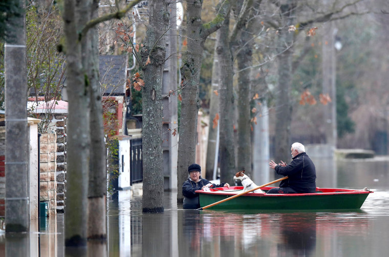 Image: Residents on a small boat leave home in a flooded street of Villeneuve-Saint-Georges