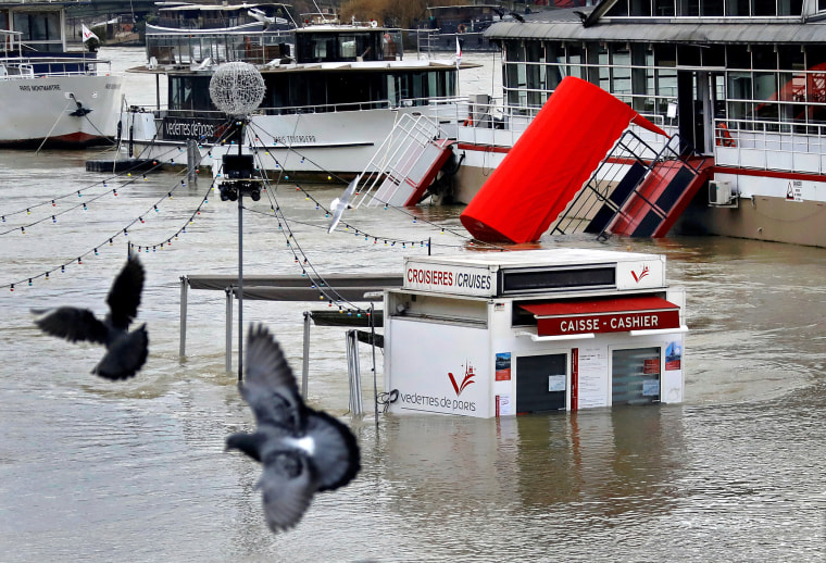 Image: A ticket booth for sightseeing boats is partly submerged by the River Seine in Paris