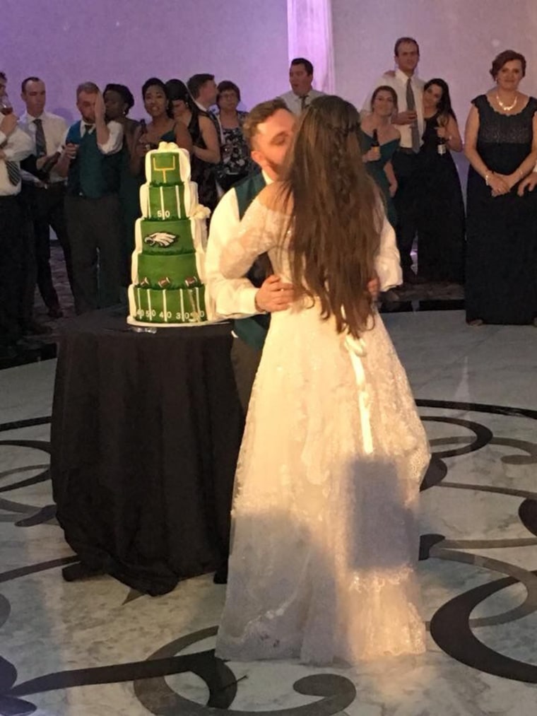 A couple whose wedding cake was traditional on one side, Philadelphia Eagles themed on the othe