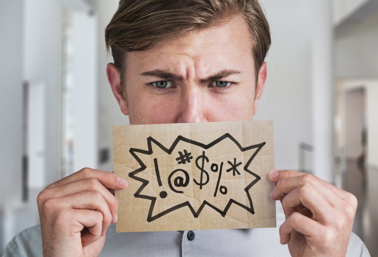 Image: A man holds a swear word sign