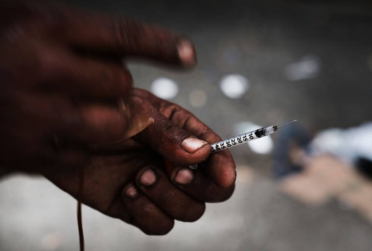 Image: A heroin user displays a needle in a South Bronx neighborhood