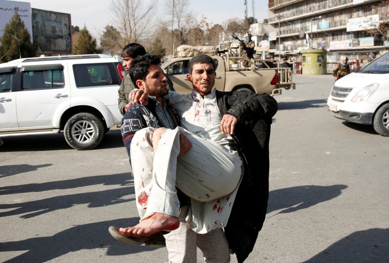 Image: Injured man is carried after a blast in Kabul