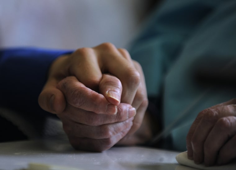 Mitchel Todd, left, a clinical social worker from Pathways Palliative Care, has known the sisters for years and visits their home often. He spends time with Rosemary and take her hand in his as they talk. New laws regarding hospice and palliative care in