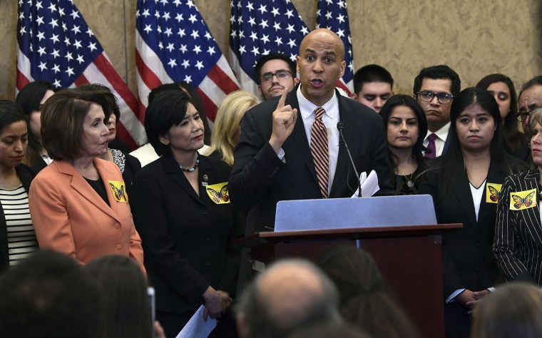 Image: Cory Booker and  Nancy Pelosi during a news conference on Capitol Hill