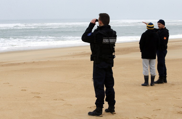 Image: French police search the coastline for clues in the disappearance of Quiksilver surfwear CEO Pierre Agnes.