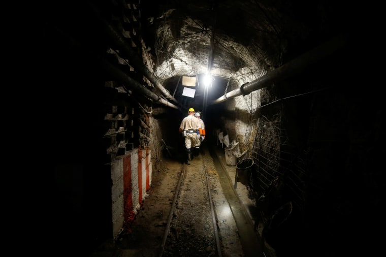 Mine security officials walk underground at Sibanye Gold's Masimthembe mine in Westonaria
