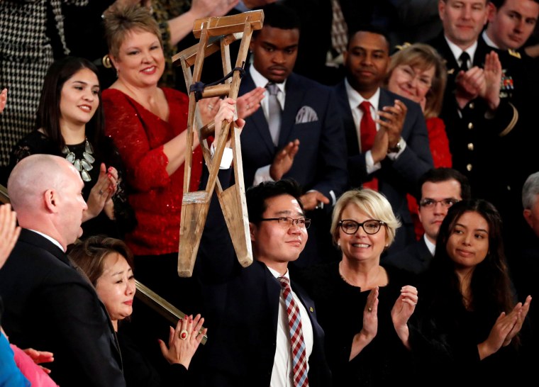 Image: North Korean defector Ji Seong-ho holds up his crutches during the State of the Union