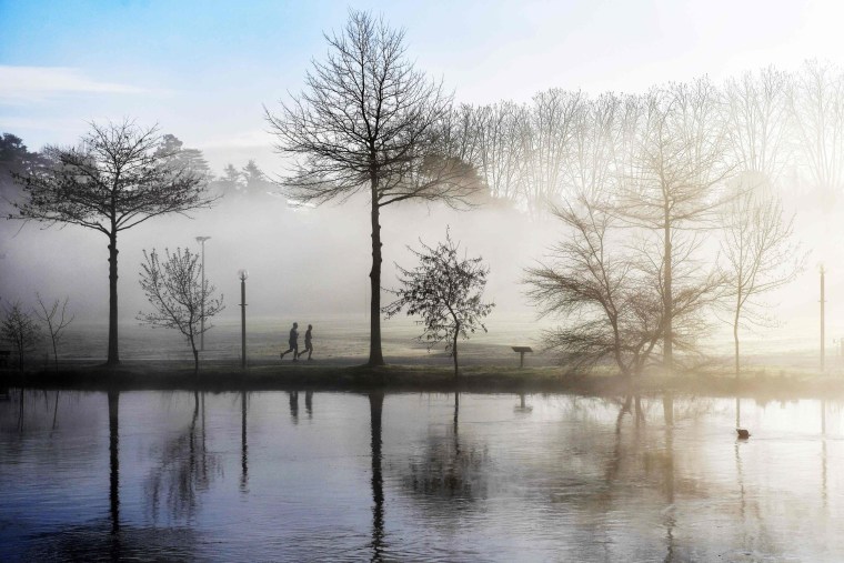 Image: Joggers run along the banks of the Sevre Nantaise river