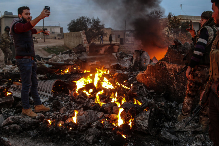 Image: People walk amidst the rubble of the Russian Sukhoi Su-25 fighter jet scattered on the ground, in Ma'saran village near Saraqeb city, in Eastern Idlib countryside, Syria, on Feb. 3, 2018.