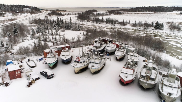 Image: Fishing boats sit idle in Dillingham, Alaska as snow falls in January.