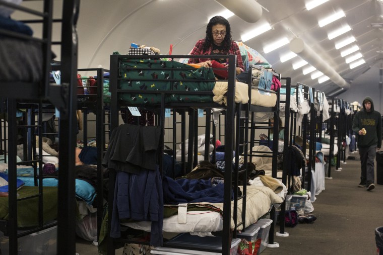 Image: Silvia Saliman sits on her bunk bed in a temporary shelter for the homeless run by the Alpha Project